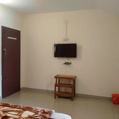 a room with a flat screen tv on a wall at HAVEN COTTAGE in Ooty
