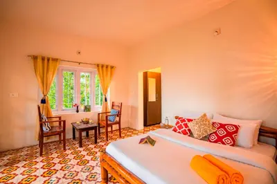 a bedroom with a bed and a table and chairs at Zostel Homes Wayanad, Karapuzha in Wayanad