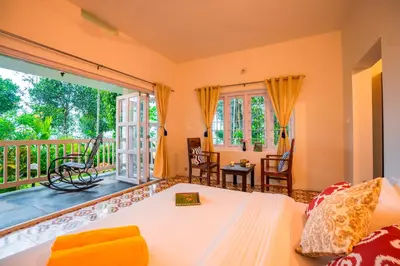 a bedroom with a bed and a balcony at Zostel Homes Wayanad, Karapuzha in Wayanad