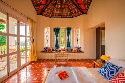 a living room with a couch and some windows at Zostel Homes Wayanad, Karapuzha in Wayanad