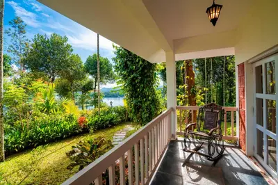 a porch with a bench and a view of a garden at Zostel Homes Wayanad, Karapuzha in Wayanad