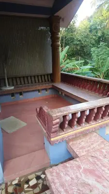 a balcony of a house with a wooden railing at Ben's Villa Kannur ! in Kannur