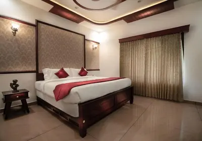 a bedroom with a large bed with red pillows at Wayanad Mace Mansion in Kenichira