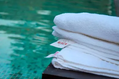 a stack of towels next to a swimming pool at Wayanad Mace Mansion in Kenichira
