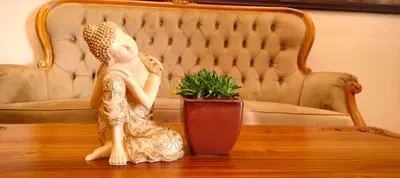 a statue of a woman sitting on a table with a plant at Wayanad Mace Mansion in Kenichira