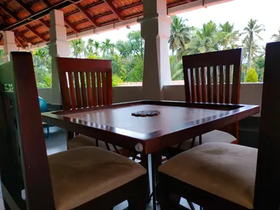a dining room table and chairs with a window at Wayanad Mace Mansion in Kenichira