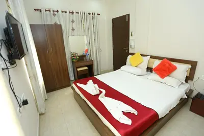 a bedroom with a bed with a red blanket on it at Hotel Innate Inn in Alwaye