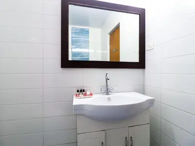 a bathroom with a white sink and a mirror at The Byke Sunshine Grand in Ooty