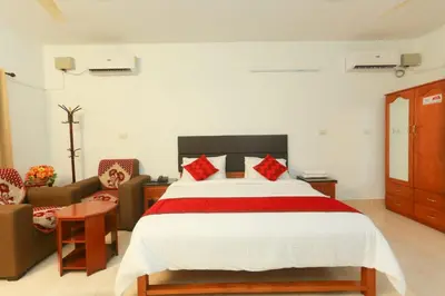 a bedroom with a bed and a couch at KTDC Tamarind Kondotty in Kondotti