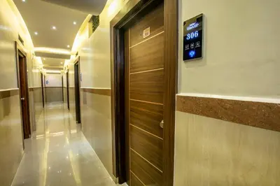 a elevator in a building with a clock on the wall at Aishwarya Suites in Mysore