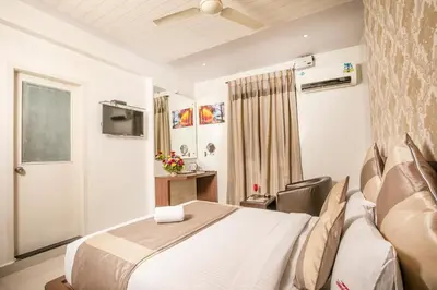 a hotel room with a bed and a television at Aishwarya Suites in Mysore