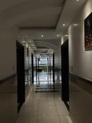 a hallway in a building with glass doors and tile floors at ABUDHABI RESIDENCY in Palakkad