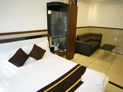 a hotel room with a bed and a couch at ABUDHABI RESIDENCY in Palakkad