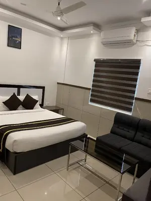 a bedroom with a bed and a couch at ABUDHABI RESIDENCY in Palakkad