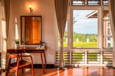 a room with a desk and a large window at Zostel Homes Wayanad, Vythiri in Wayanad