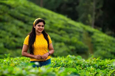 a woman in yellow shirt standing in a tea plantation at Zostel Homes Wayanad, Vythiri in Wayanad
