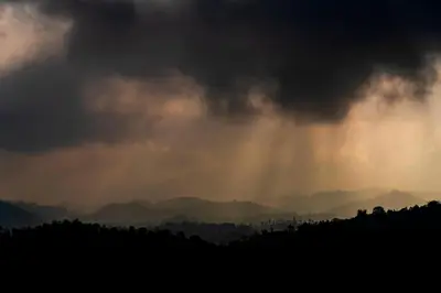 a stormy sky with rays of light shining through the clouds at Zostel Homes Wayanad, Vythiri in Wayanad