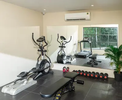 a gym with two exercise bikes and a mirror at Oshin Wayanad in Wayanad