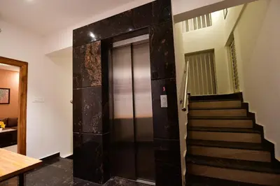 a hallway with a wooden door and stairs at Xcel Luxury Hotel Apartments-Home Living Redefined in Mysore