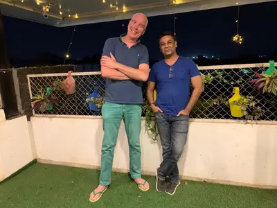 two men standing on a balcony with their arms crossed at Xcel Luxury Hotel Apartments-Home Living Redefined in Mysore