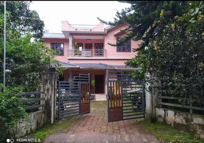 a pink house with a gate and a fence at Puzhayoram home stay, Palakkuli, Mananthavadi wayanad kerala in Mananthavady