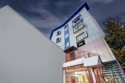 a tall white building with blue trim at Super Townhouse Mysore City Centre Formerly Hotel Mahendra in Mysore