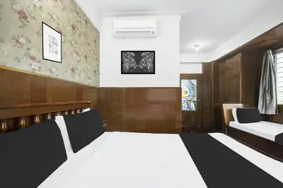 a bedroom with a bed and a couch at Super Townhouse Mysore City Centre Formerly Hotel Mahendra in Mysore