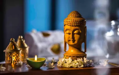 a gold statue with a candle on a table at GReaT Trails Wayanad by GRT Hotels in Wayanad