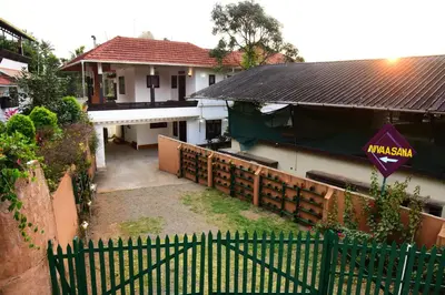 a house with a fence in front of it at Nivaasana Bed & Breakfast in Kalpetta