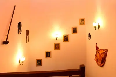 a wall with pictures and lights on a wall at Nivaasana Bed & Breakfast in Kalpetta