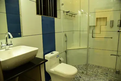 a bathroom with a toilet and a sink and a shower at Nivaasana Bed & Breakfast in Kalpetta