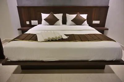 a bedroom with a large bed with a wooden headboard at Mysore Royale in Mysore