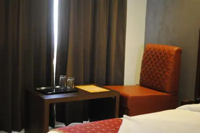 a room with a desk and a chair and a table at Mysore Royale in Mysore