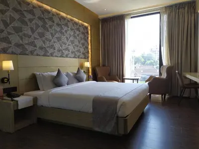 a hotel room with a bed and a large window at MothiMahal Residency Thrissur in Trichūr