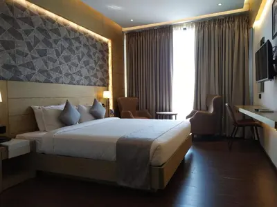 a hotel room with a bed and a television at MothiMahal Residency Thrissur in Trichūr