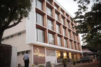 a man is standing in front of a building at MothiMahal Residency Thrissur in Trichūr