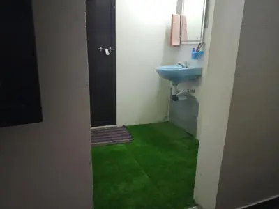 a bathroom with a sink and a green floor at Kalamana Serene in Chāvakkād