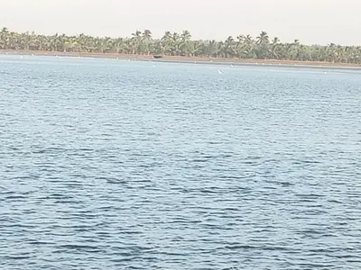 a large body of water with a beach in the background at Kalamana Serene in Chāvakkād