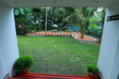 a view of a courtyard with plants and an umbrella at NARMADA POOL VILLA (KAVERI) in Perintalmanna