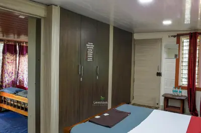 a bedroom with a bed and wooden cabinets at D signature Homestay By Lexstays in Kushālnagar