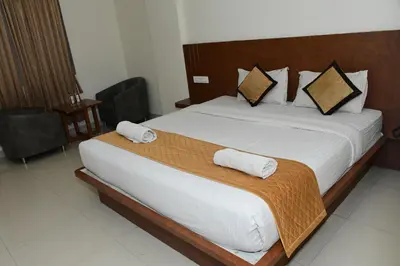 a bedroom with a large bed with two towels on it at Sai Vihaar Inn & Suites in Mysore