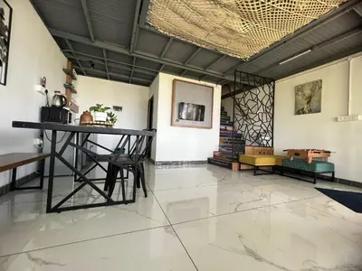 a room with a table and chairs in it at Wild root stay- Aster Chalet in Wayanad