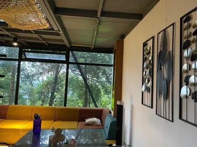 a living room with a yellow couch and a table at Wild root stay- Aster Chalet in Wayanad