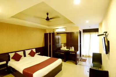 a bedroom with a bed and a desk and a television at Shastri Paradise opst to KSRTC Bus Stand in Mysore