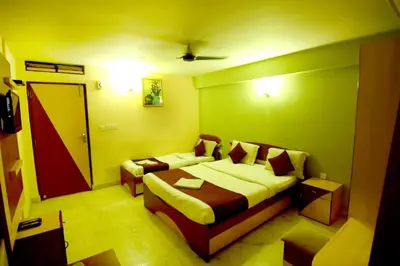 a bedroom with a bed and a couch in it at Shastri Paradise opst to KSRTC Bus Stand in Mysore