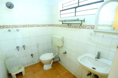 a bathroom with a toilet and a sink at Shastri Paradise opst to KSRTC Bus Stand in Mysore