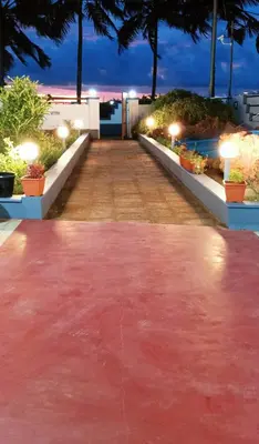 a red carpet in the middle of a walkway at night at Beach Nest in Kannur