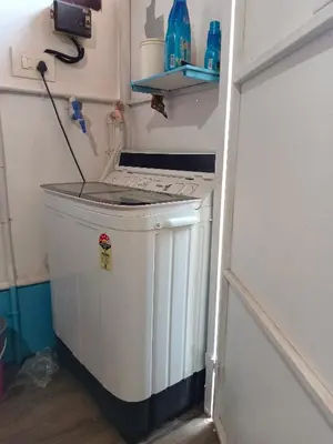 a washer and dryer in a corner of a room at Beach Nest in Kannur