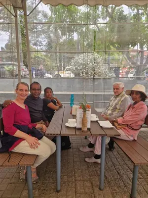 a group of people sitting at a picnic table at Narmada Holiday Home in Ooty
