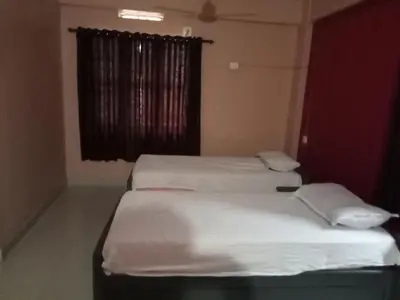 two twin beds in a room with a window at SAFA RESIDENCY in Perintalmanna